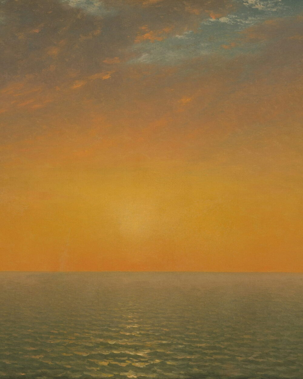 A low sun over a calm sea under a warm orange sky.