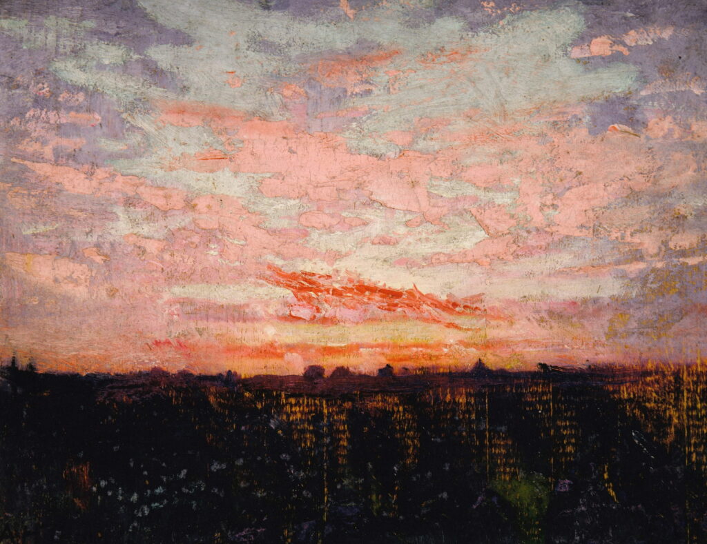 Pink and red clouds over a dark strip of land at dusk.