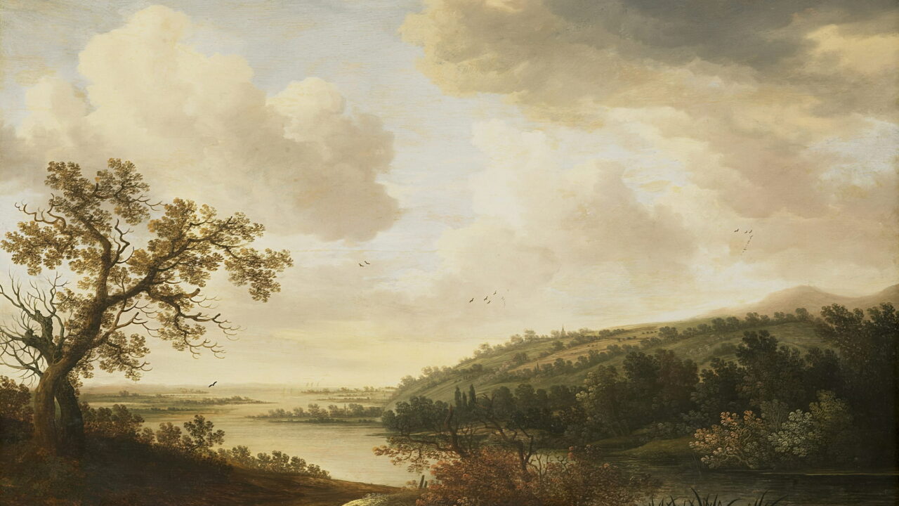 A wide river runs through a green valley under tall summer clouds.