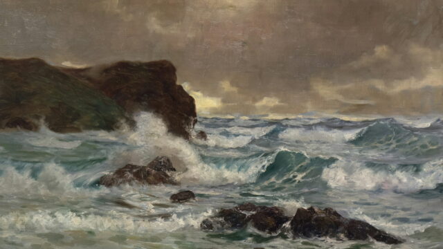 Gray waves break over dark rocks below a low, heavy sky.
