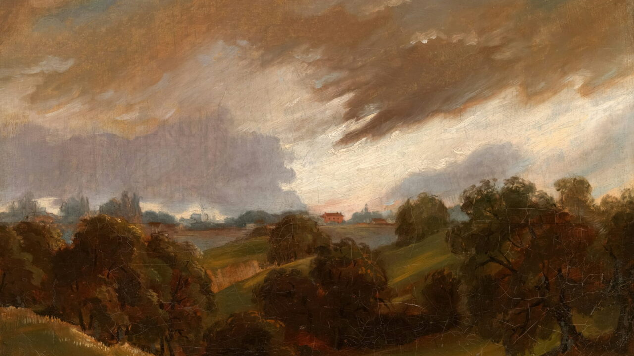 Brown storm clouds roll over wooded hills and a far valley.