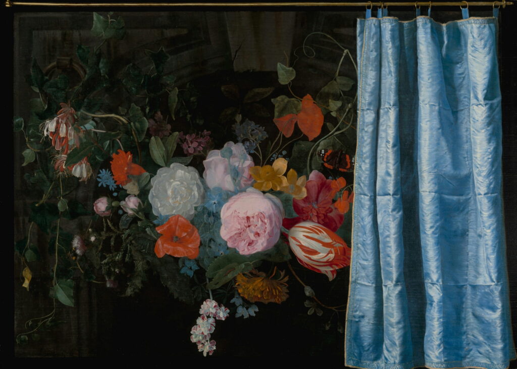 A hanging garland of roses and tulips beside a blue silk curtain.