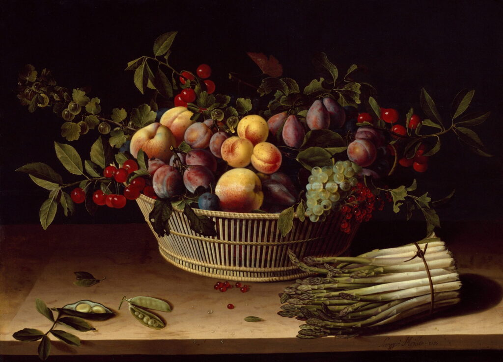 A woven basket of peaches, plums, and cherries beside a bunch of white asparagus.