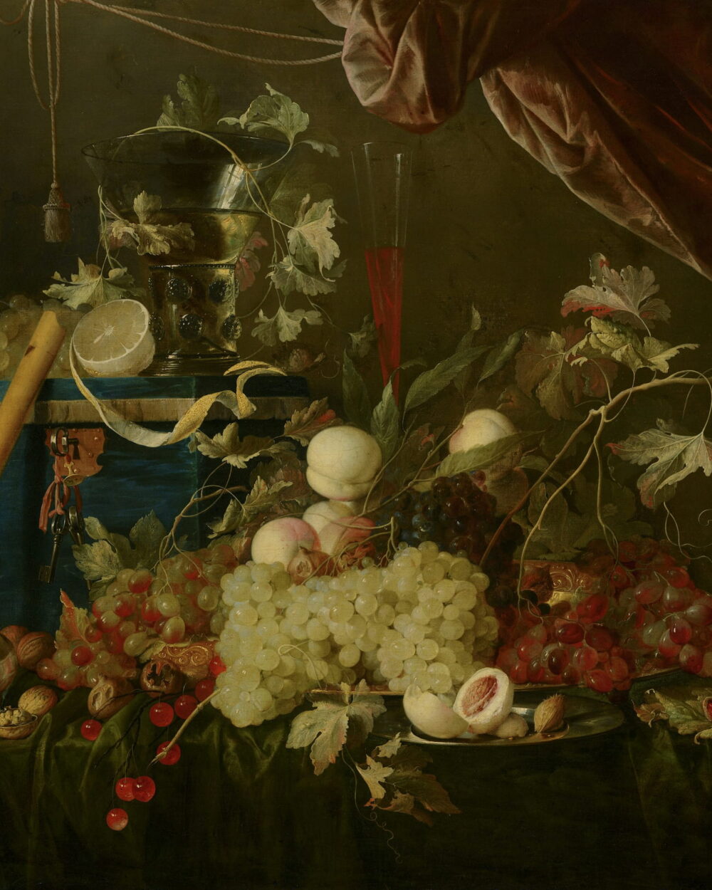 Grapes, peaches, and a silver pitcher on a table under a dark red curtain.