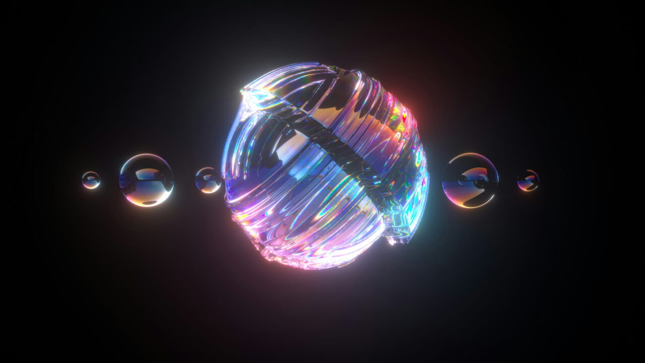 A rainbow glass sphere with small glass beads in a line on black.